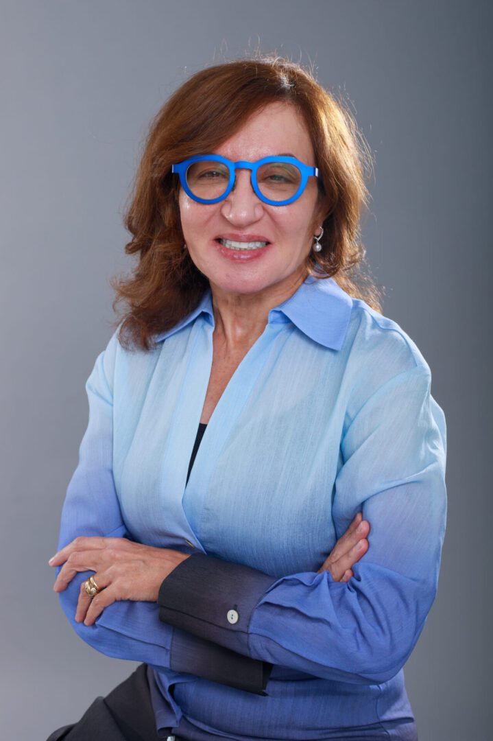 A woman with glasses and blue shirt