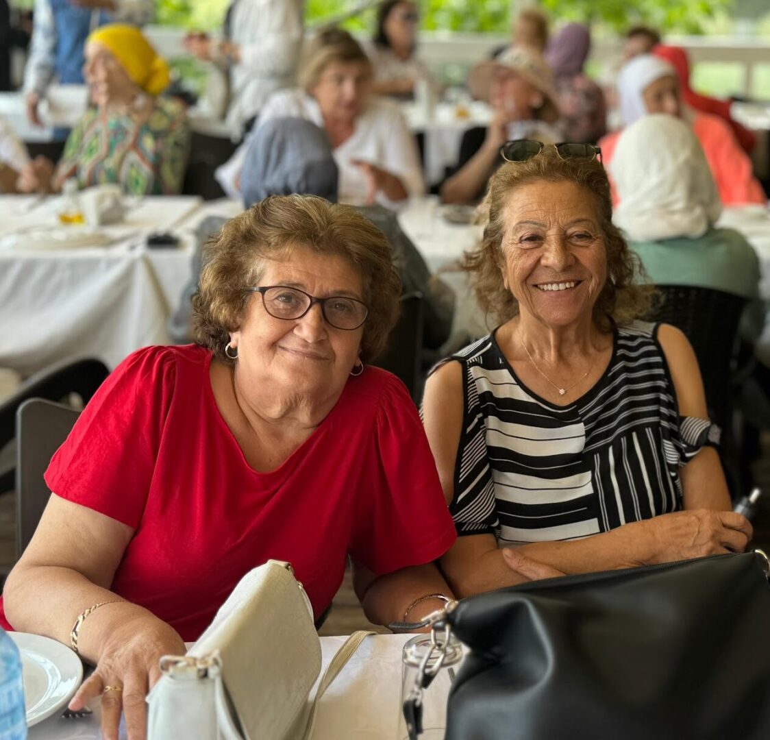 Two women smiling in public setting.