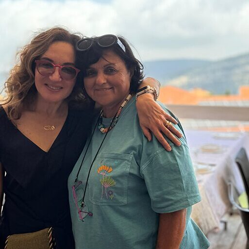 Two women smiling for the camera in building.